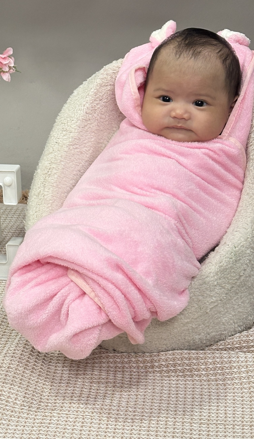 Dorothea Maeve wrapped in pink on a soft chair